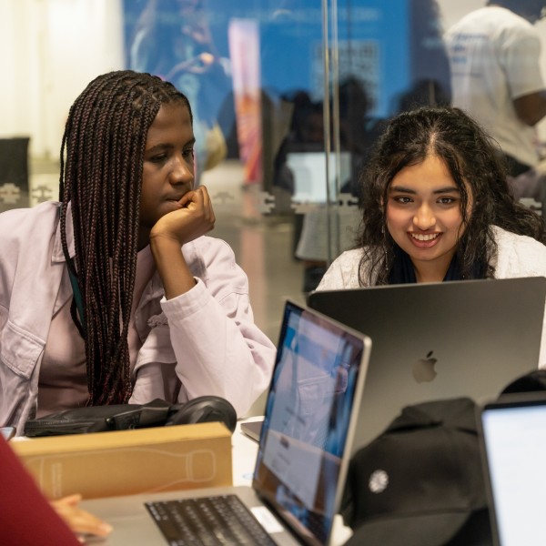 Two young women sitting at a laptop in a workshop at Next Tech Fest 2025